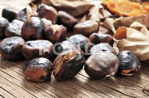 Roasted chestnuts on a rustic wooden table Stock Photos
