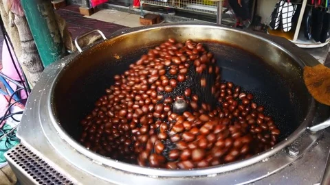 Roasted chestnuts with sugar laced in hot pebbles. Sweet, delicious cuisine, Stock Footage 83292734