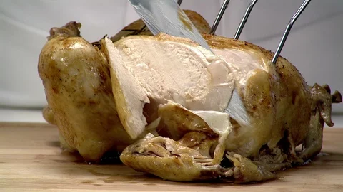 Roasted chicken breast being sliced with large carving knife 1 Video stock 102136825