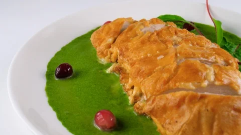 Roasted chicken fillet in cheese crust on green creamed spinach sauce Stock Footage 87565983