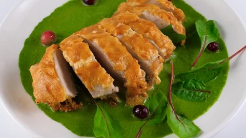 Roasted chicken fillet in cheese crust on spinach sauce, served in Restaurant 스톡 동영상 87565998