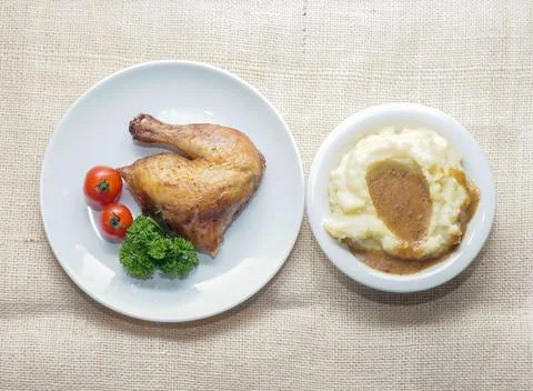 Roasted Chicken Leg Quarter with Mashed Potatoes on Rustic Background Foto stock