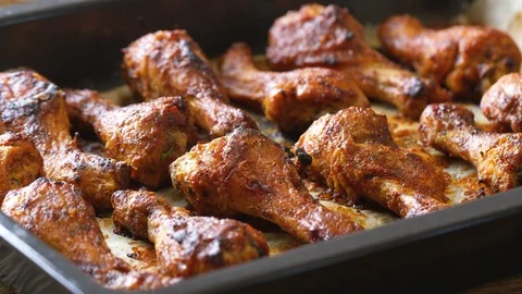 Roasted chicken legs BBQ in baking pan decorating with sesame and herbs. Vide Stock Footage 118824458
