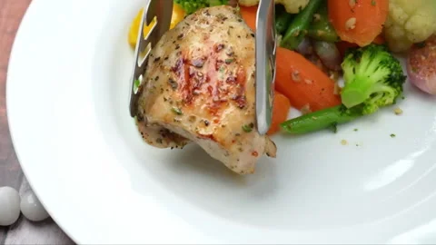 Roasted chicken thighs pieces serving on the white plate. Real time Close-up Video stock 286072360