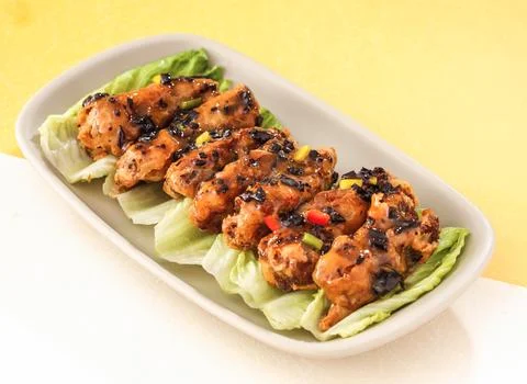 Roasted Chicken wings Bones with Olive Sauce served in dish isolated on bac.. Stock Photos