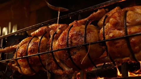 Roasted chickens on spit grilled over wood fire on big bbq barbecue with a spoon Stock Footage 199261863