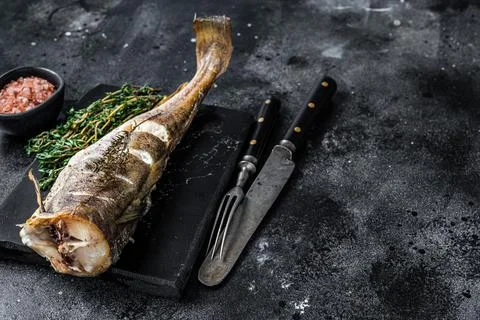 Roasted cod white fish with thyme on marble board. Black background. Top view Stock Photos