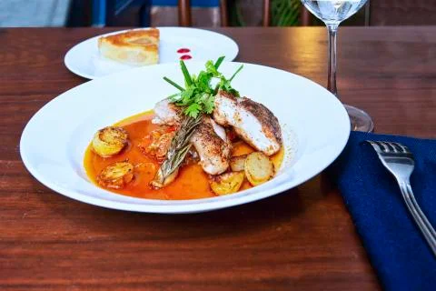 Roasted codfish with baked potatoes and sauce Stock Photos