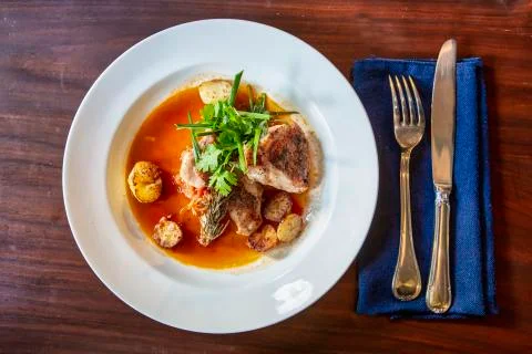 Roasted codfish with baked potatoes and sauce Stock Photos