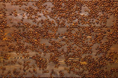 Roasted coffe beans spreaded over wooden board - full frame background, high Stock Photos