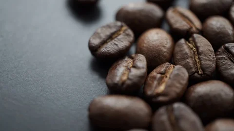 Roasted coffee bean rotating clockwise on black background, selective focus 库存影片 121108985