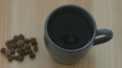 Roasted coffee beans and a cup of black coffee on the table Stock Footage 158836932