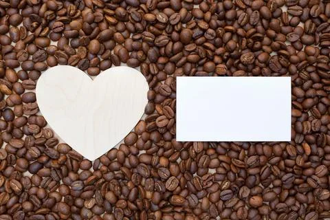 Roasted coffee beans and an empty wooden heart. Place for your text and label Stock Photos