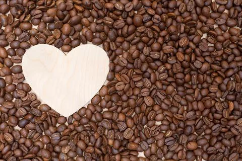 Roasted coffee beans and an empty wooden heart. Place for your text and label Stock Photos