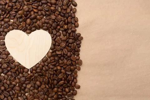 Roasted coffee beans and an empty wooden heart. Place for your text and label Stock Photos