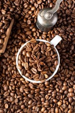 Roasted coffee beans and star anise in a mug on a background of coffee beans. Stock-Fotos