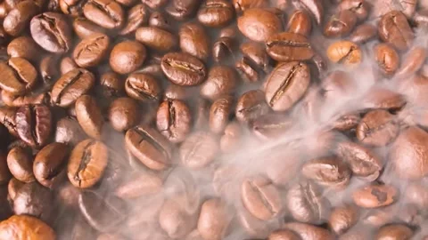 Roasted coffee beans and steam, swirling, close up. Stock Footage 151345086