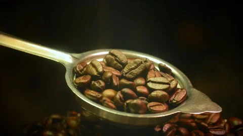 Roasted coffee beans in an antique metal spoon with smoke stock video 動画素材 345159342