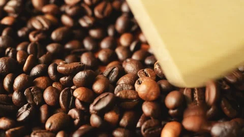 Roasted coffee beans are mixed with a wooden spatula Stock Footage 136175730