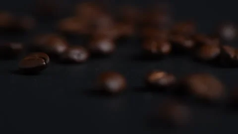 Roasted coffee beans are rolled on black table surface. Stock-Footage 172539119