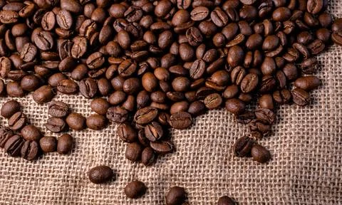 Roasted coffee beans background. Arabica beans on a jute bag Stock Photos