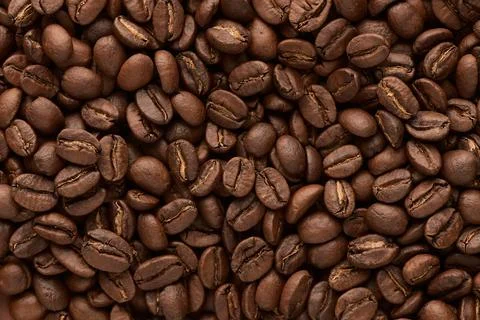 Roasted coffee beans background. Close up top view. Stock Photos