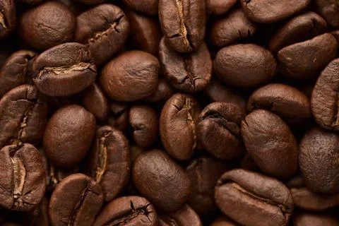 Roasted coffee beans background. Close up top view. Stock Photos