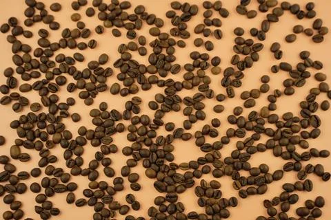Roasted coffee beans on a beige background. Top view, copy space. Stock Photos