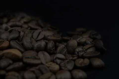 Roasted coffee beans on black background. Stock Photos