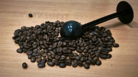 Roasted Coffee Beans with Black Measuring Scoop on Wooden Table Stock Photos