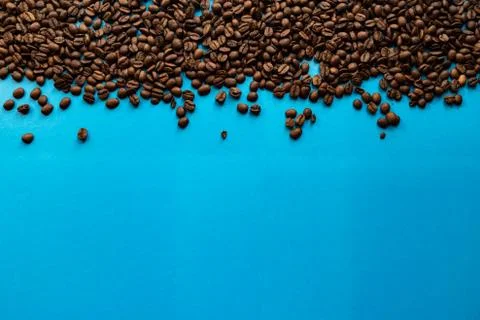 Roasted coffee beans with a blue background. Stock Photos