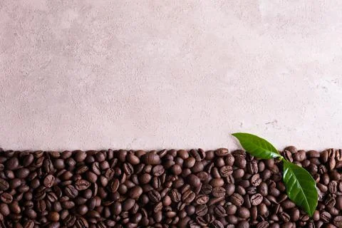 Roasted coffee beans border on a light brown background. Stock Photos
