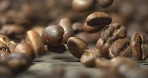 Roasted coffee beans bouncing across wooden table in super slow motion 動画素材 342590602