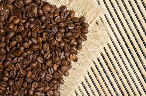 Roasted coffee beans on burlap and on a wicker napkin, close-up. Foto stock