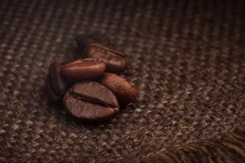 Roasted Coffee Beans on Burlap Sack Background Close-Up Stock Photos