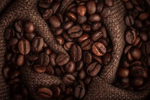 Roasted Coffee Beans on Burlap Sack Background High Angle Shot Foto stock