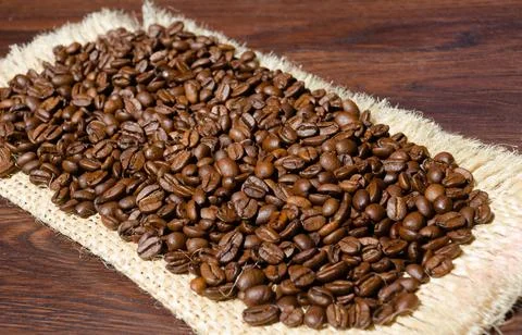 Roasted coffee beans close-up on burlap. Stock Photos