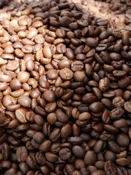 Roasted coffee beans close up in the light and shadow 스톡 사진