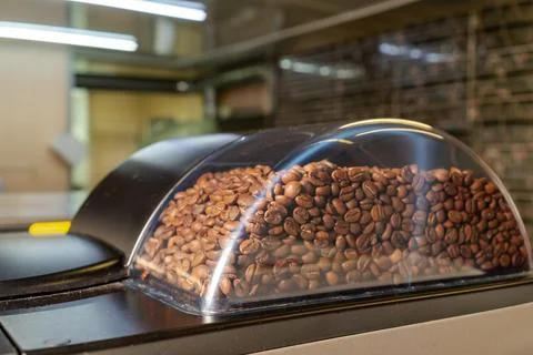 Roasted coffee beans in a coffee machine to prepare a delicious coffee drink at Stock Photos