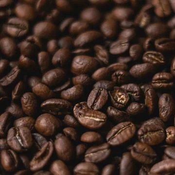 Roasted coffee beans creating a rich texture background, producing aromatic.. Stock Photos