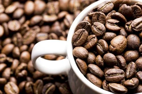 Roasted coffee beans in a cup, on dark background, close-up image, space for  Stock Photos