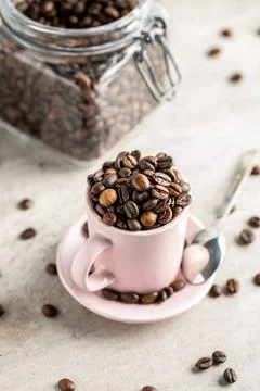 Roasted coffee beans in cup Roasted coffee beans in cup on white table. Co... Stock Photos