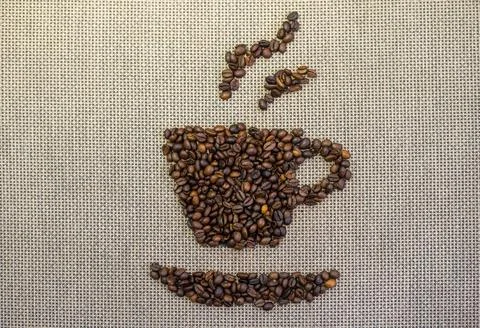 Roasted coffee beans in cup shape on burlap 스톡 사진