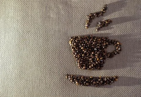 Roasted coffee beans in cup shape on burlap Stock Photos