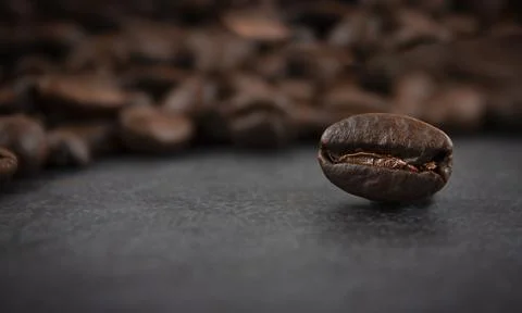 Roasted coffee beans on a dark background, close up. Soft focus. Stock Photos