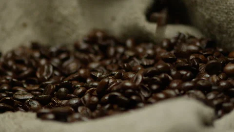 Roasted coffee beans drop into a burlap texture Video stock 142071794