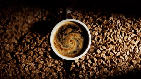 Roasted coffee beans falling around white ceramic cup. Stock Footage 328628393