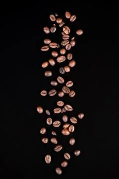 Roasted coffee beans falling on black background with copy space Foto stock