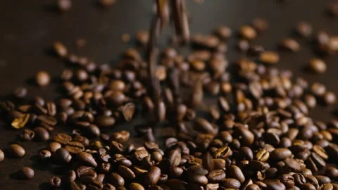 Roasted coffee beans falling on brown table. indoor shot, stable shot, 4k. Stock Footage 347973395