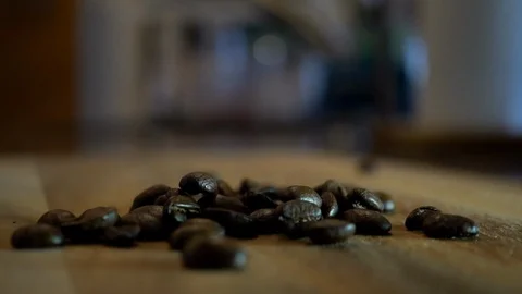 Roasted coffee beans falling onto rustic kitchen countertop in slow motion Stock Footage 104712458